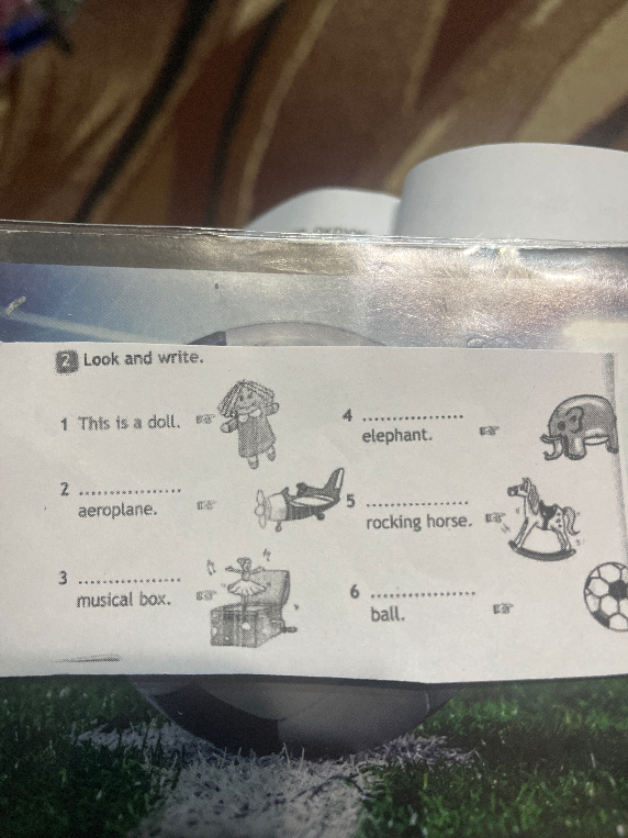 Look and write: This is a doll... aeroplane... musical box... elephant... rocking horse... ball.