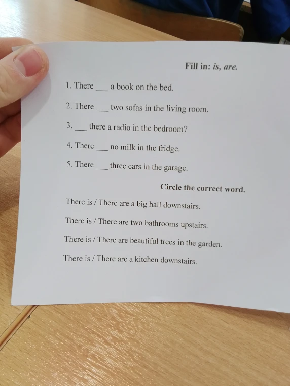Fill in: is, are. 1. There ___ a book on the bed. 2. There ___ two sofas in the living room. 3. ___ there a radio in the bedroom? 4. There ___ no milk in the fridge. 5. There ___ three cars in the garage. Circle the correct word.